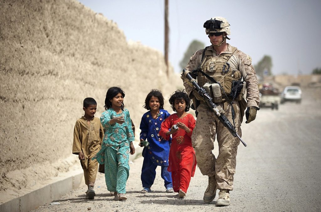 Gruppe afghanischer Kinder mit American Marine auf Streifendienst zu Fuß